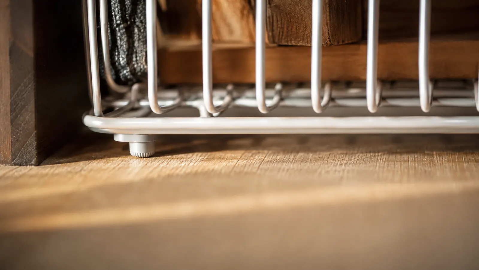 Close-up of rubber grip strips under the base of an expandable lid organizer on a cabinet floor